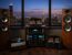High-end audiophile stereo system with premium speakers, tube amplifiers, and reference audio components overlooking the Chicago skyline with Willis Tower in the background.